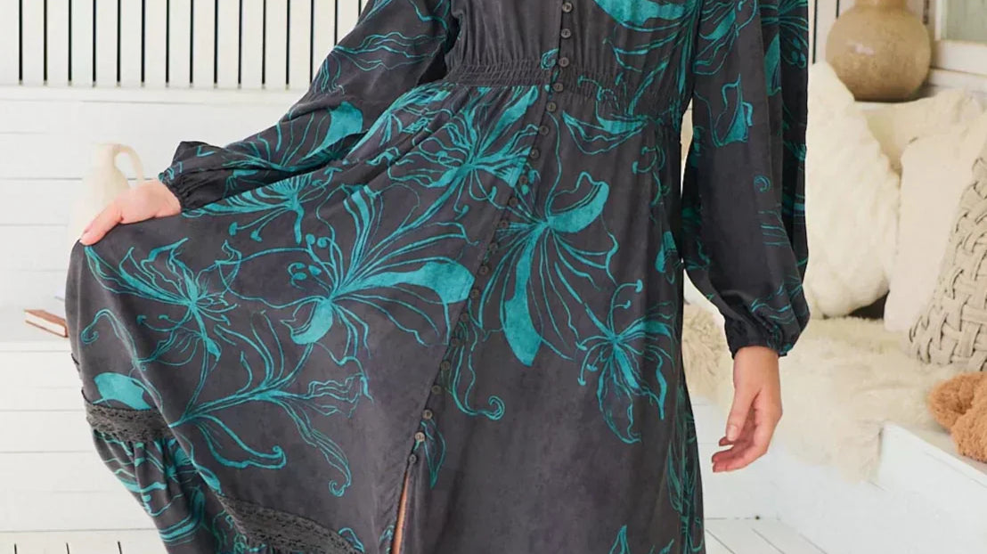 Model wears boho maxi dress with a black base and floral turquoise print.