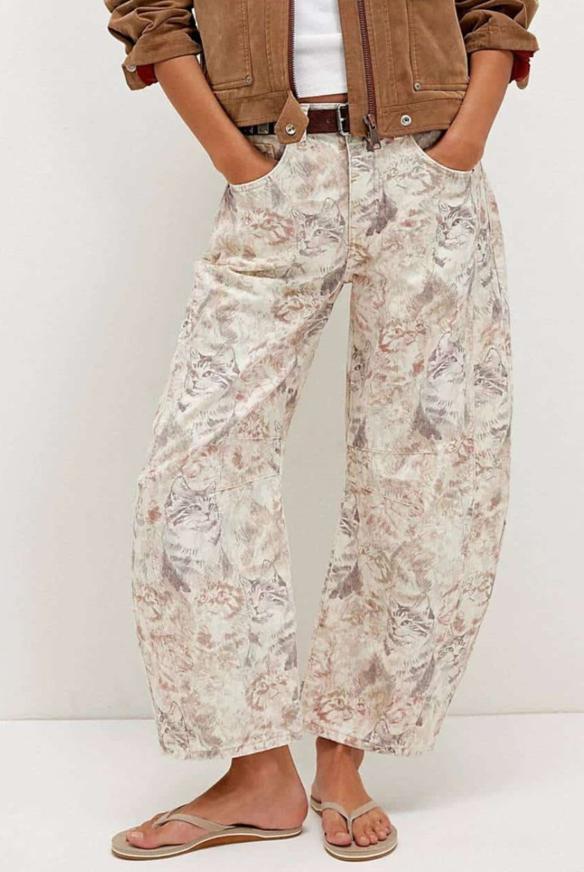 Woman wearing midi-rise artistic floral print barrel jeans in blush and taupe tones - relaxed boho cotton denim Australia.