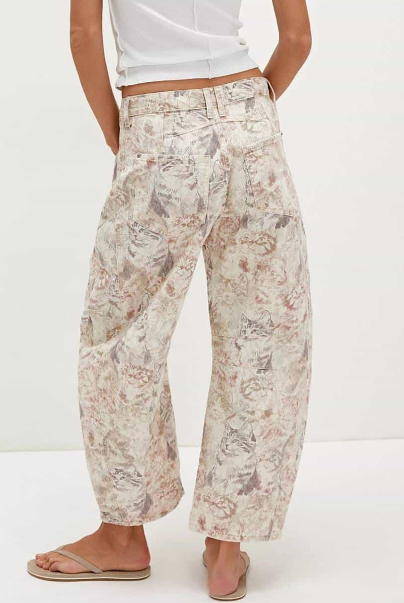 Woman wearing midi-rise artistic floral print barrel jeans in blush and taupe tones - relaxed boho cotton denim Australia.