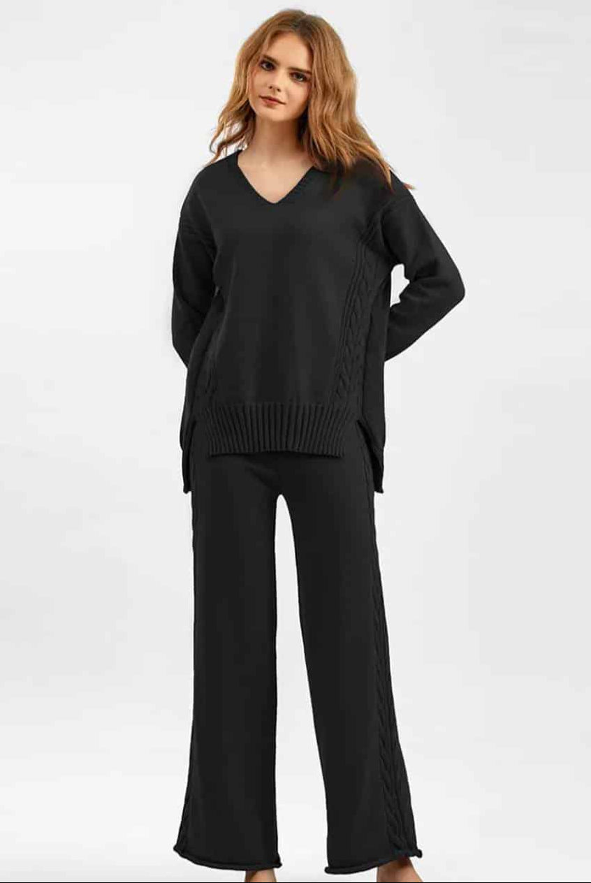 Woman wearing black cable knit lounge set with wide-leg pants and relaxed V-neck sweater —100% cotton winter knitwear.