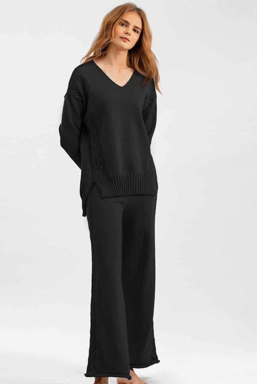 Woman wearing black cable knit lounge set with wide-leg pants and relaxed V-neck sweater —100% cotton winter knitwear.