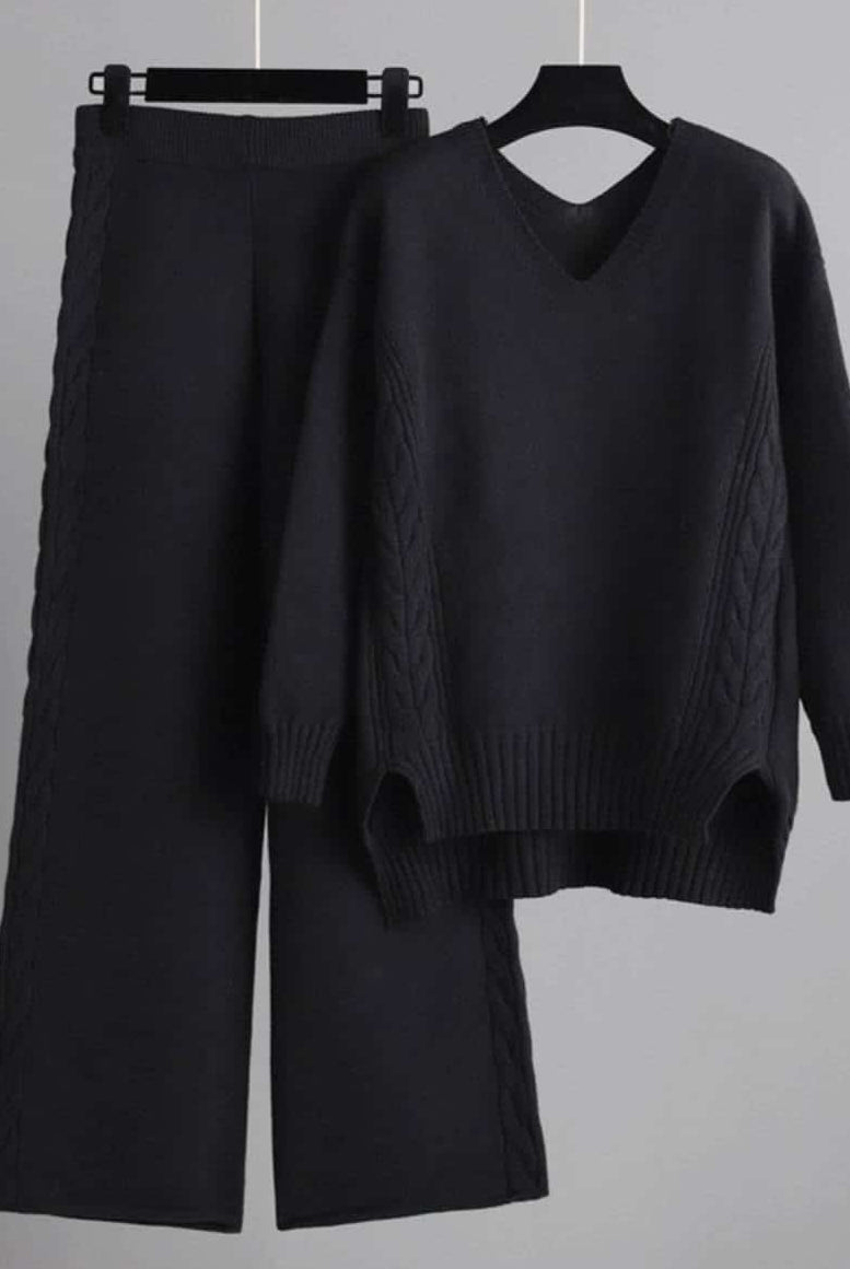 Woman wearing black cable knit lounge set with wide-leg pants and relaxed V-neck sweater —100% cotton winter knitwear.