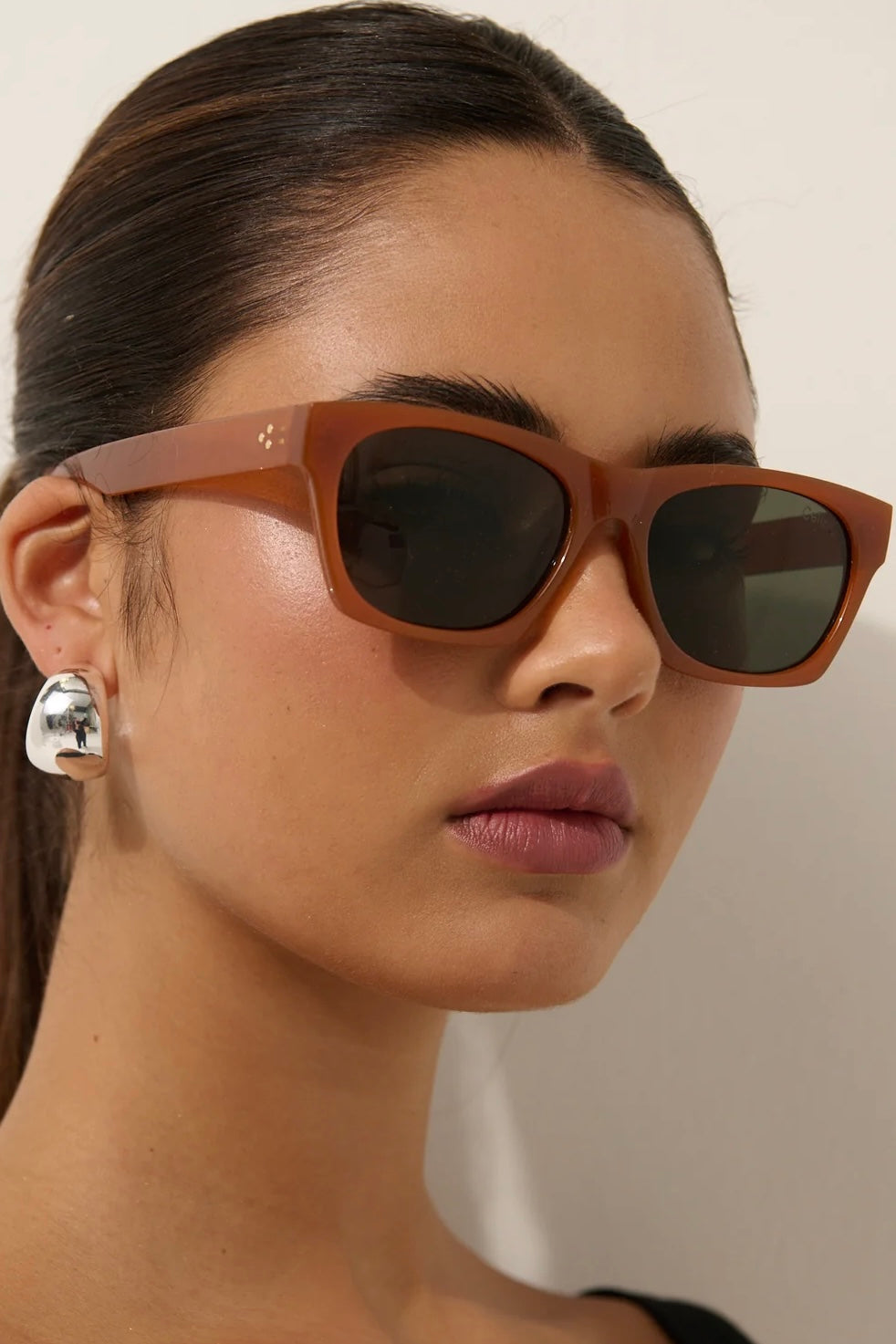 Woman in brown square boho sunglasses with slick hair and dark lip— vintage-inspired summer style Australia.