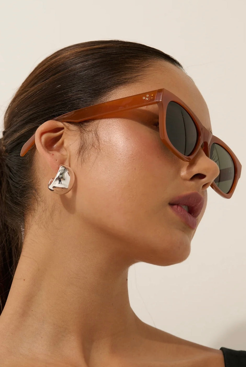 Woman in brown square boho sunglasses with slick hair and dark lip— vintage-inspired summer style Australia.