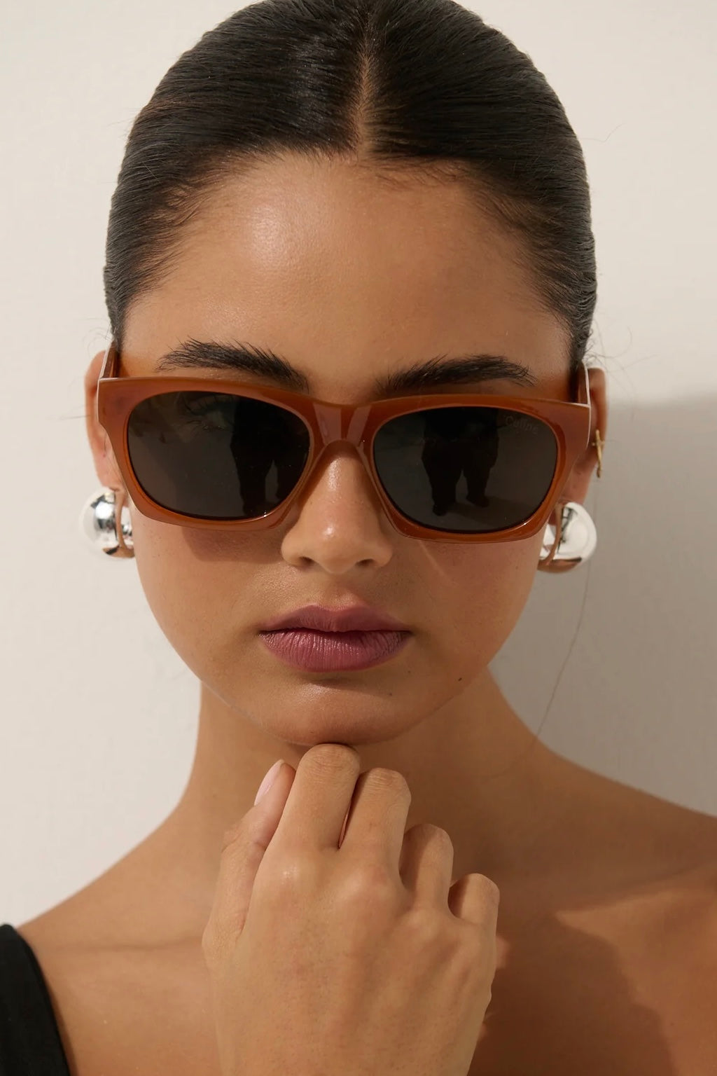 Woman in brown square boho sunglasses with slick hair and dark lip— vintage-inspired summer style Australia.