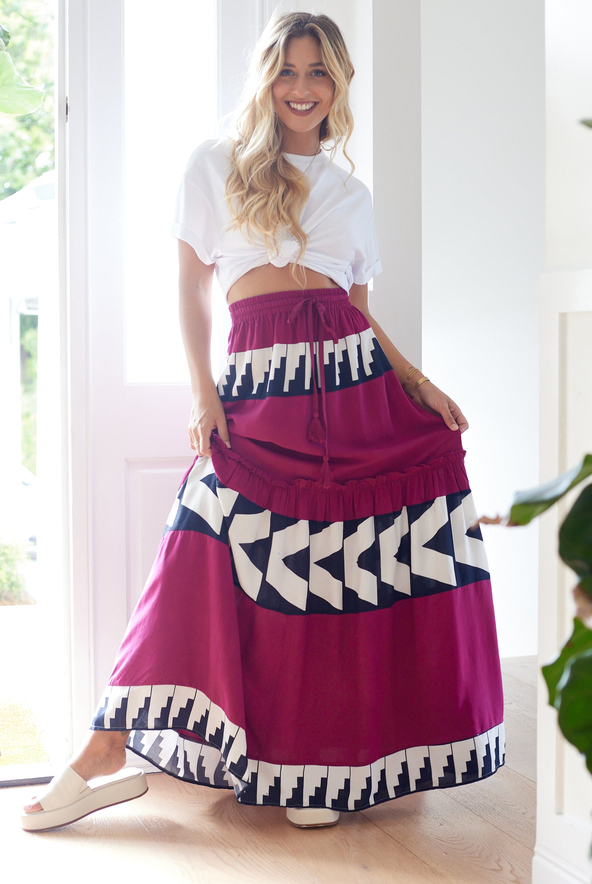 Woman wearing a colorful skirt with geometric patterns indoors.