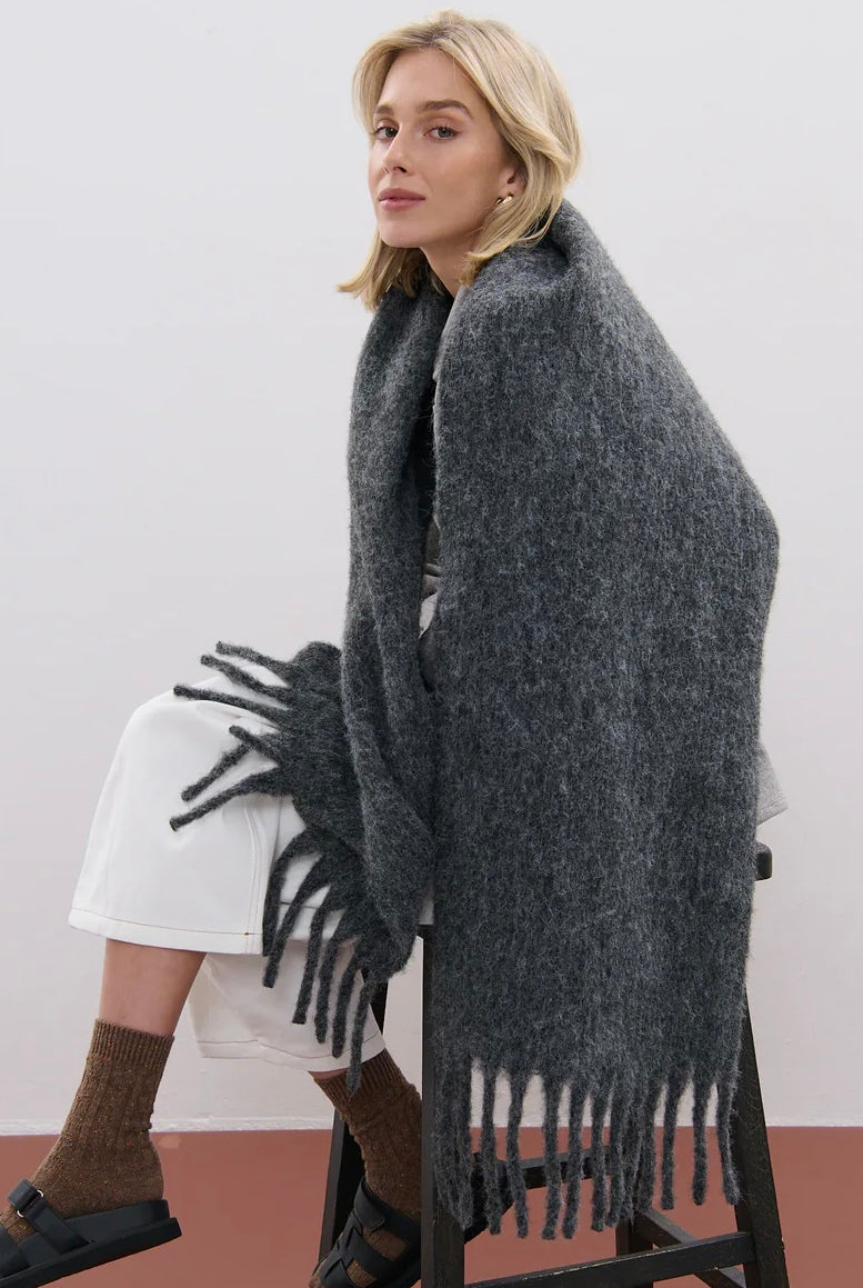 Woman wrapped in a charcoal fluffy boho wool blend scarf with fringe - The Midnight Hour winter wrap from Bohemian Love Runway.