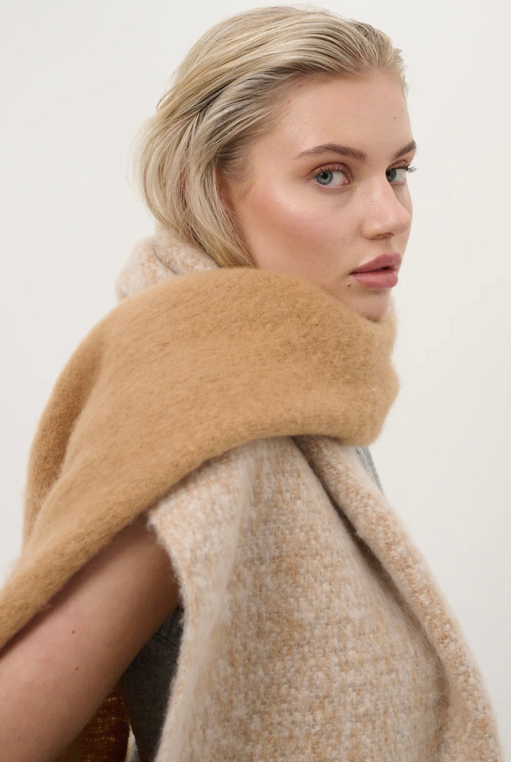 Woman wearing a caramel and beige fluffy boho scarf with fringe - Amber Light soft winter wrap by Bohemian Love Runway.