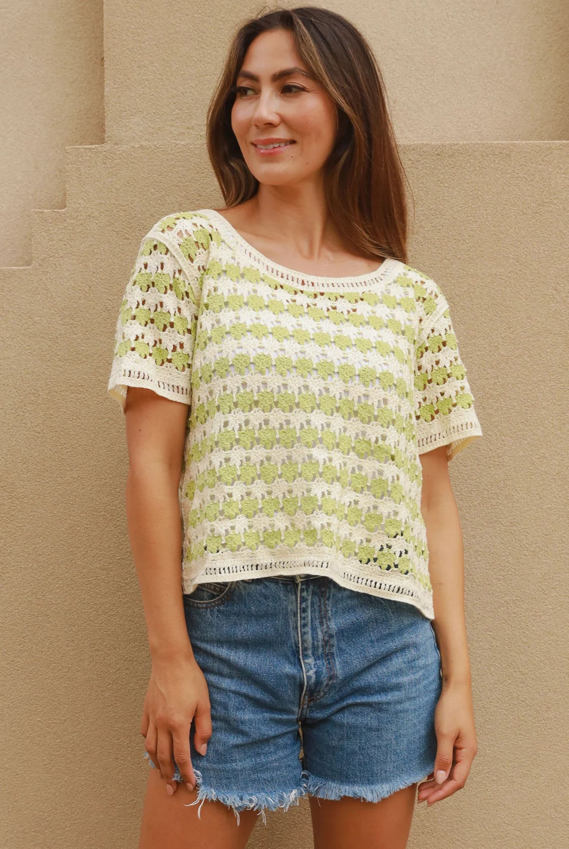 Woman wearing lime and cream crochet cotton top with vintage pattern and denim shorts - boho summer fashion Australia.