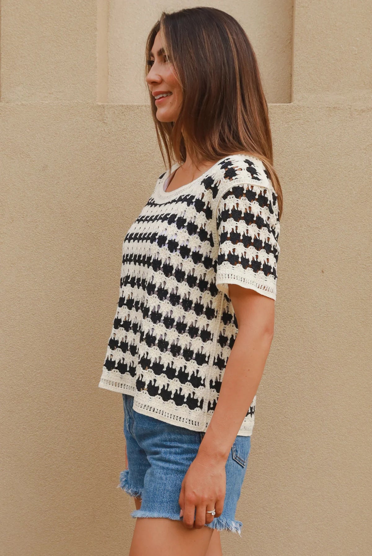 Woman wearing black and cream crochet cotton top with checkerboards pattern - boho summer fashion Australia.