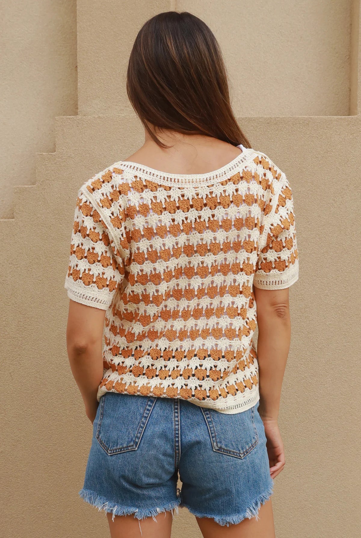 Woman wearing cram and tan crochet cotton top with boho vintage pattern - indie summer fashion Australia.