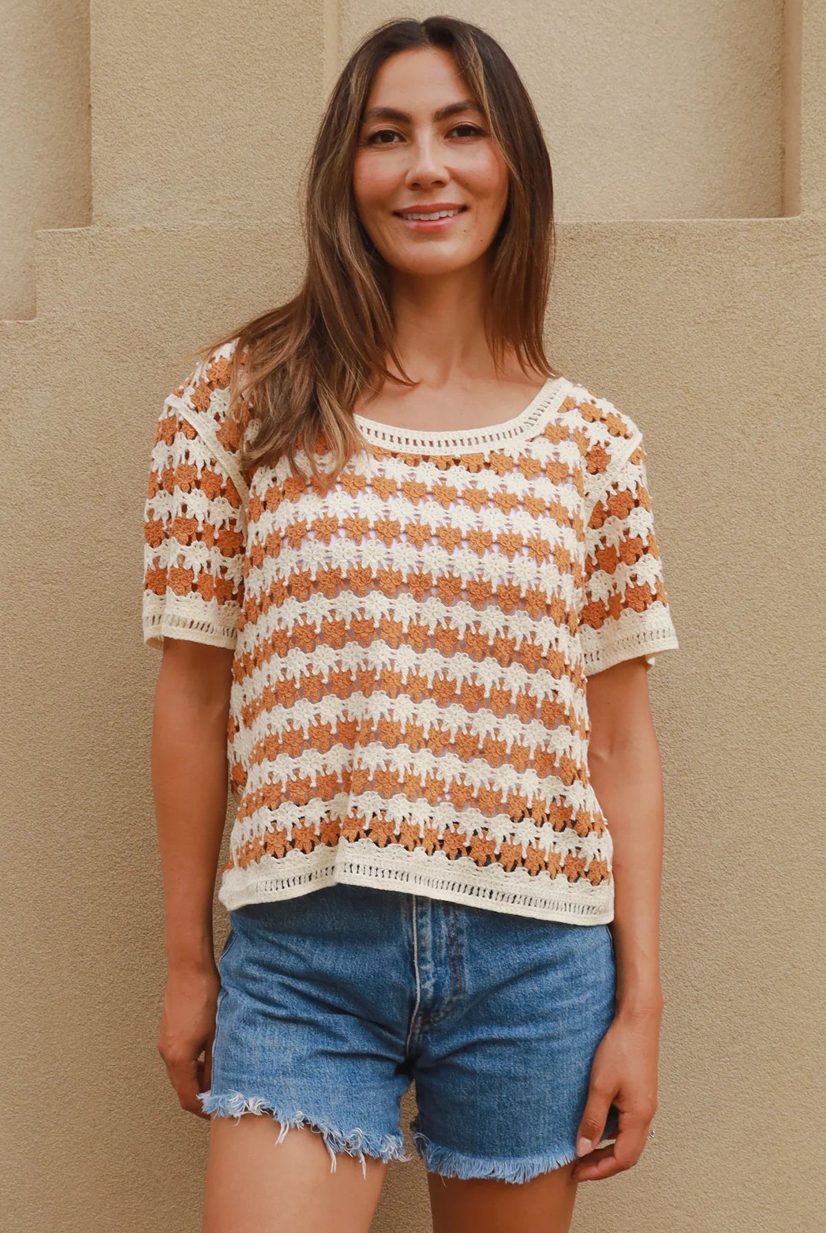 Woman wearing cram and tan crochet cotton top with boho vintage pattern - indie summer fashion Australia.
