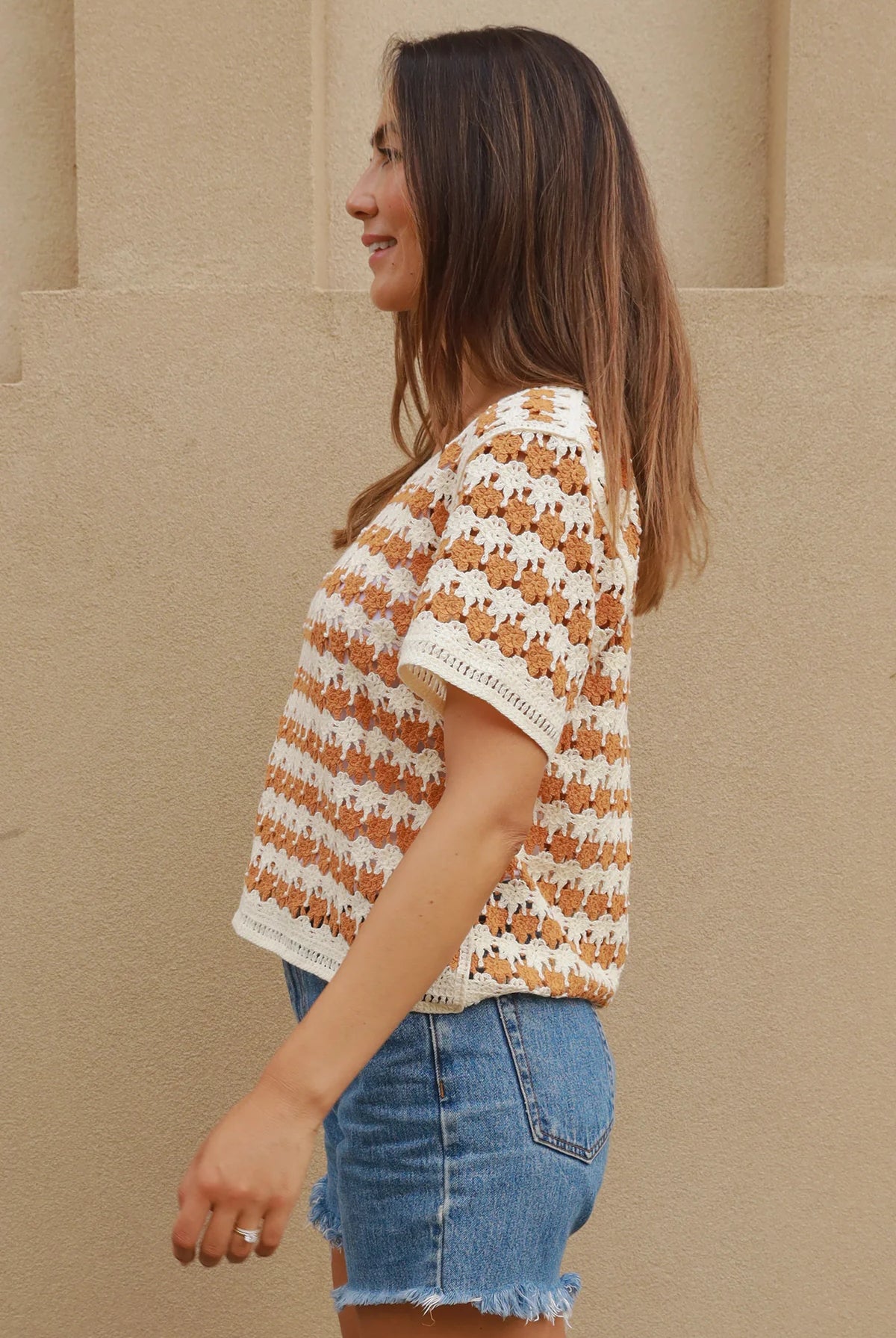 Woman wearing cram and tan crochet cotton top with boho vintage pattern - indie summer fashion Australia.