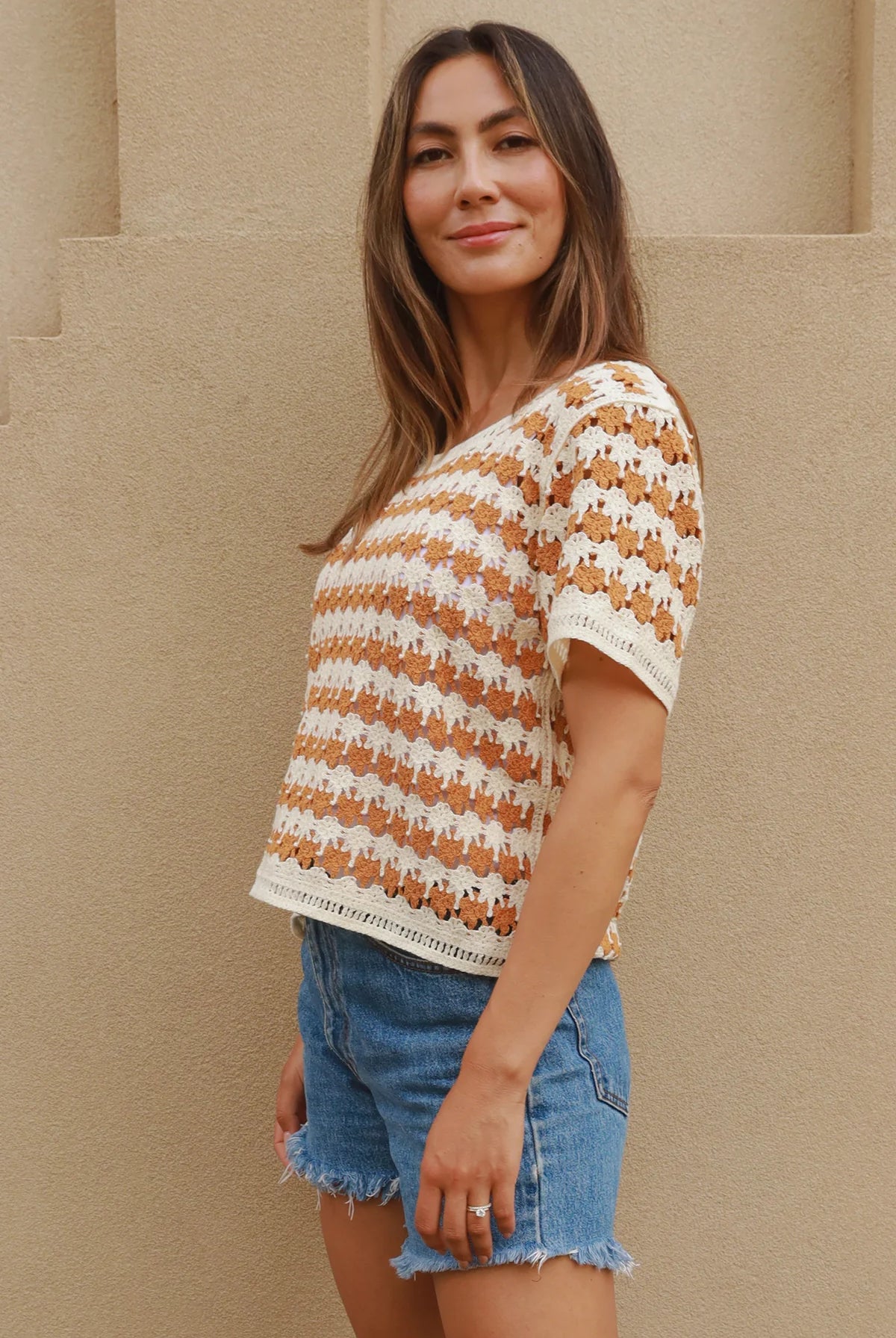 Woman wearing cram and tan crochet cotton top with boho vintage pattern - indie summer fashion Australia.