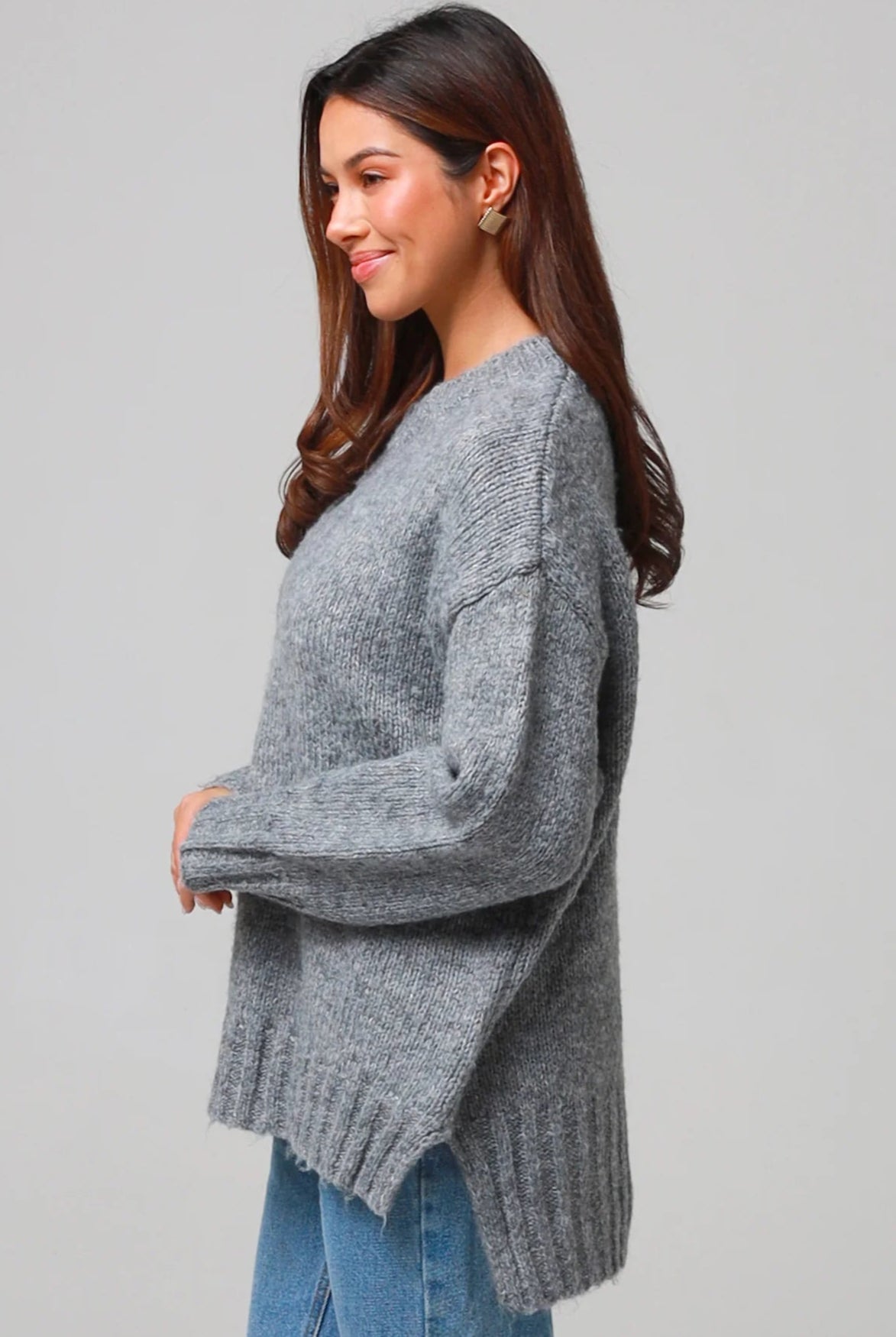 Woman wearing a grey wool blend knit jumper with ribbed cuffs and hem- boho winter jumper Australia.