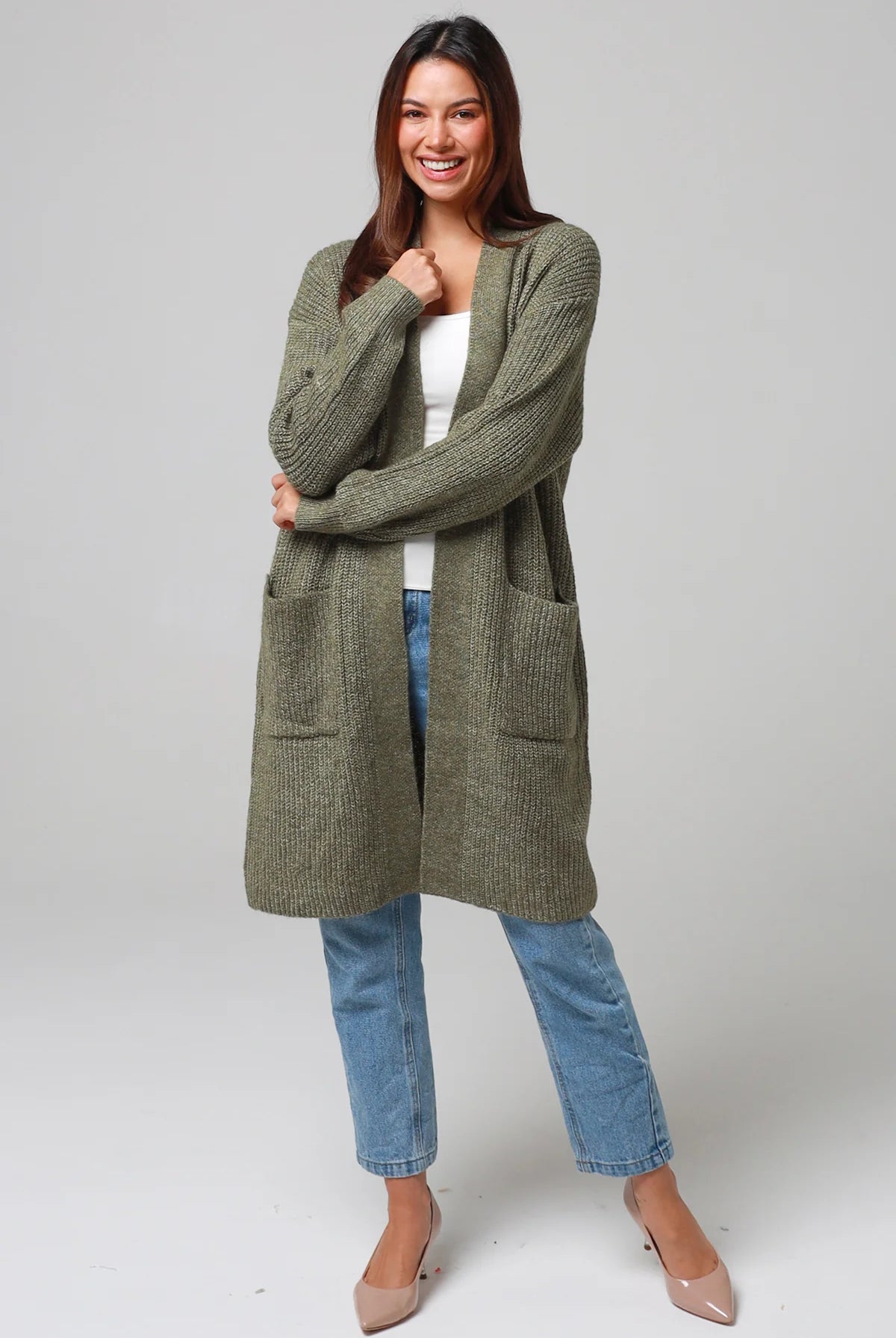 Woman in Khaki longline cardigan with patch pockets and denim - earthy boho wool blend knitwear Australia.