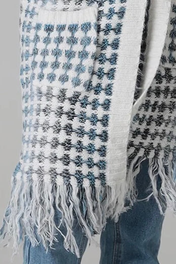 Woman wearing Juliet white and blue houndstooth longline fringe knit cardigan with drop shoulder sleeves, ribbed cuffs and front pockets by Charlotte The Label.