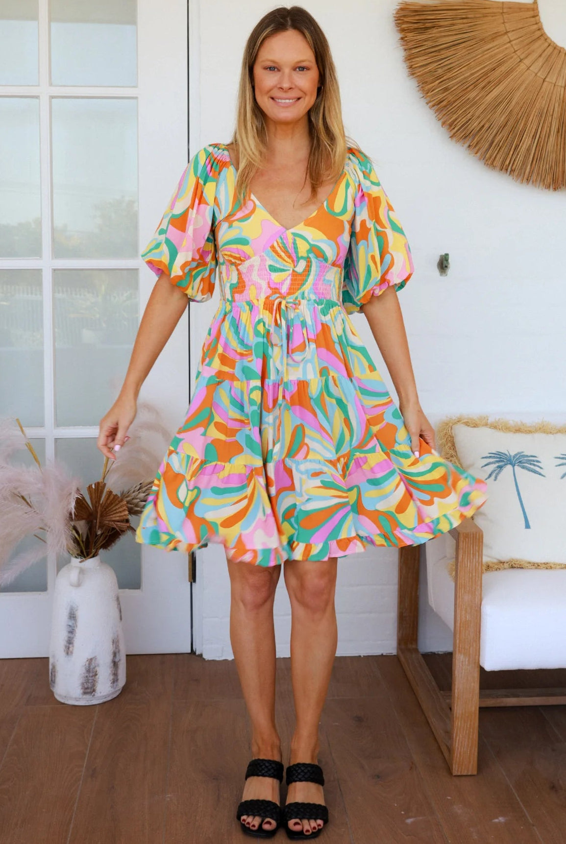Woman in multicolour boho tiered mini dress with v-neckline, puff sleeves, shirred waist and oversized hemline - Australian bohemian style