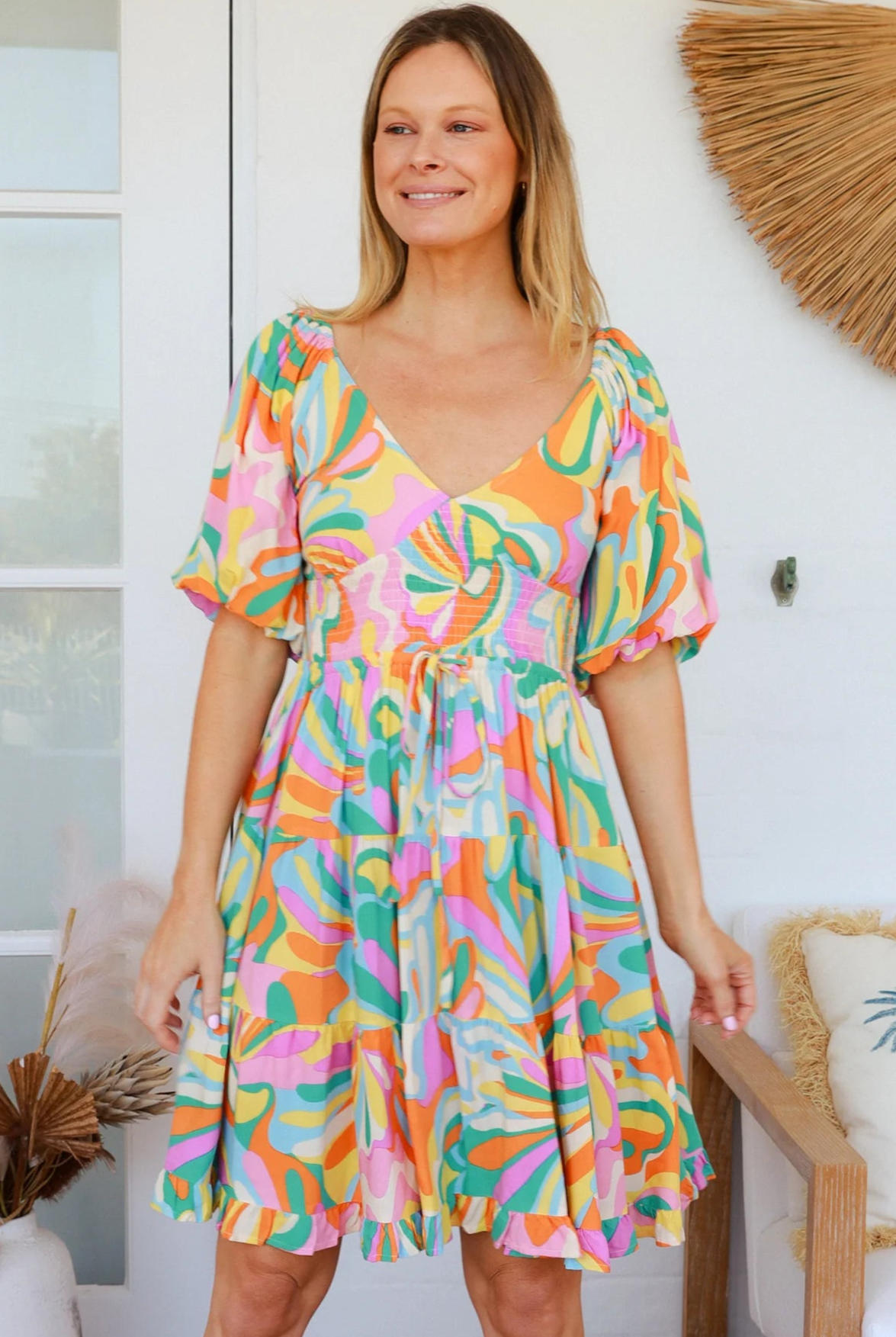 Woman in multicolour boho tiered mini dress with v-neckline, puff sleeves, shirred waist and oversized hemline - Australian bohemian style