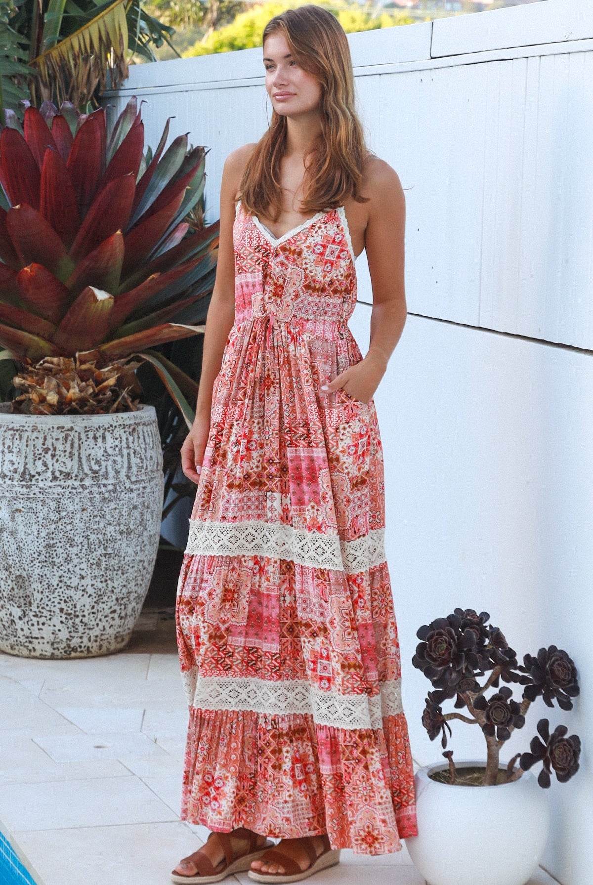 Woman wearing blush coral tiered rayon maxi dress with ivory lace, Dreamcatcher print, flowing summer boho style