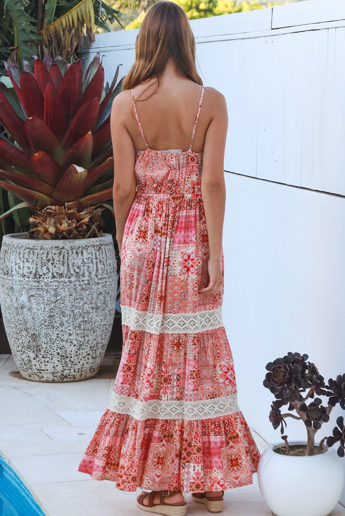 Woman wearing blush coral tiered rayon maxi dress with ivory lace, Dreamcatcher print, flowing summer boho style