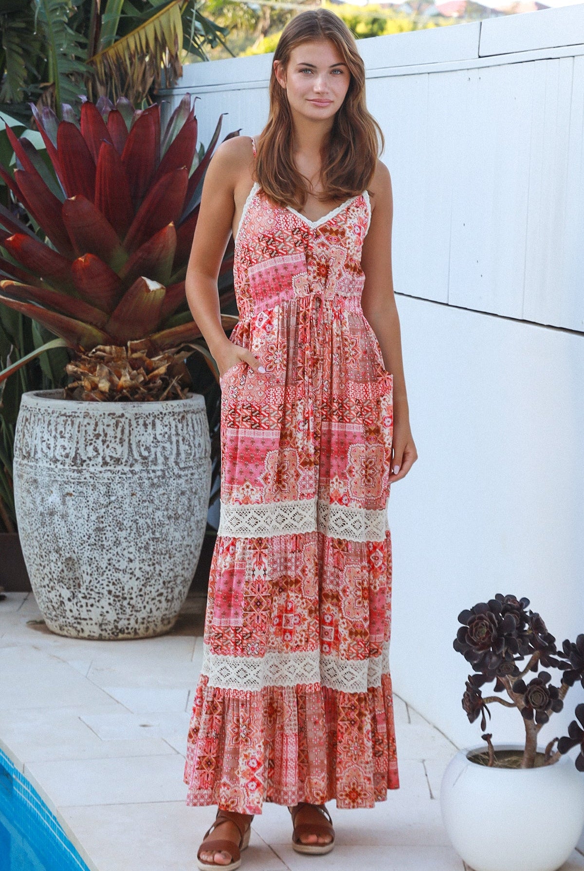 Woman wearing blush coral tiered rayon maxi dress with ivory lace, Dreamcatcher print, flowing summer boho style