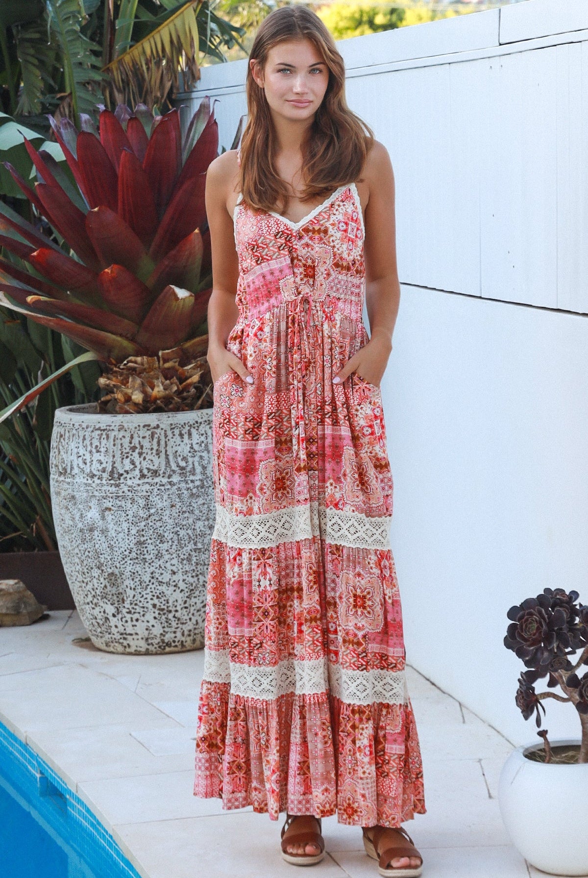 Woman wearing blush coral tiered rayon maxi dress with ivory lace, Dreamcatcher print, flowing summer boho style