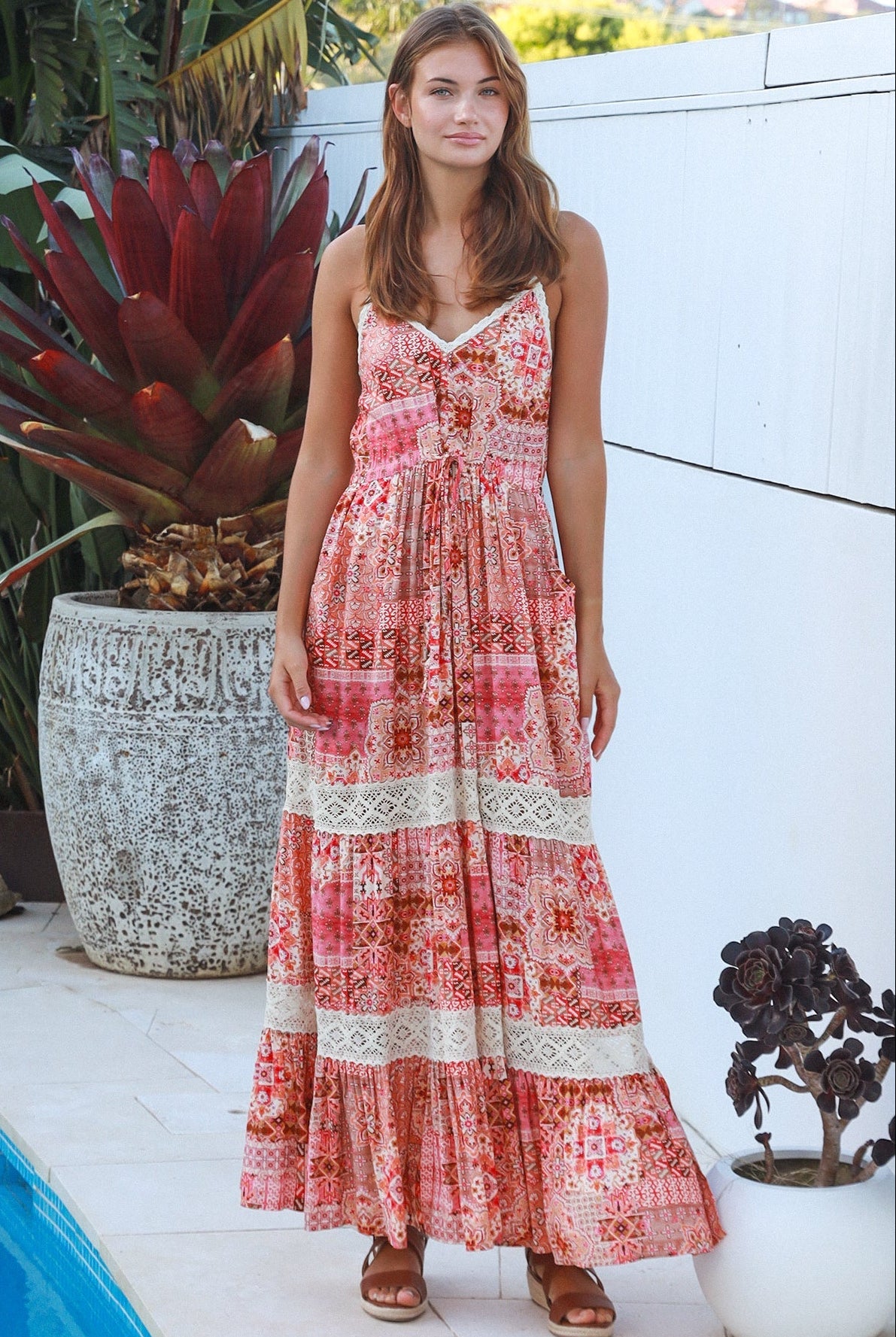 Woman wearing blush coral tiered rayon maxi dress with ivory lace, Dreamcatcher print, flowing summer boho style