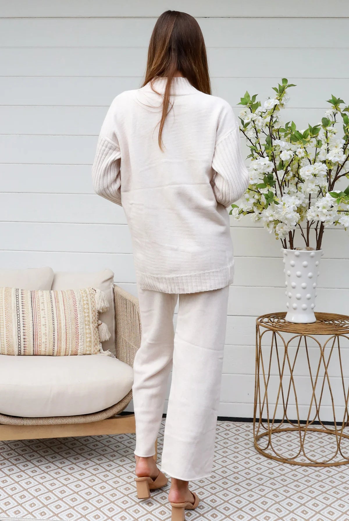 Model wearing cream knit lounge set with high-neck jumper and wide-leg pants - women's loungewear Australia.