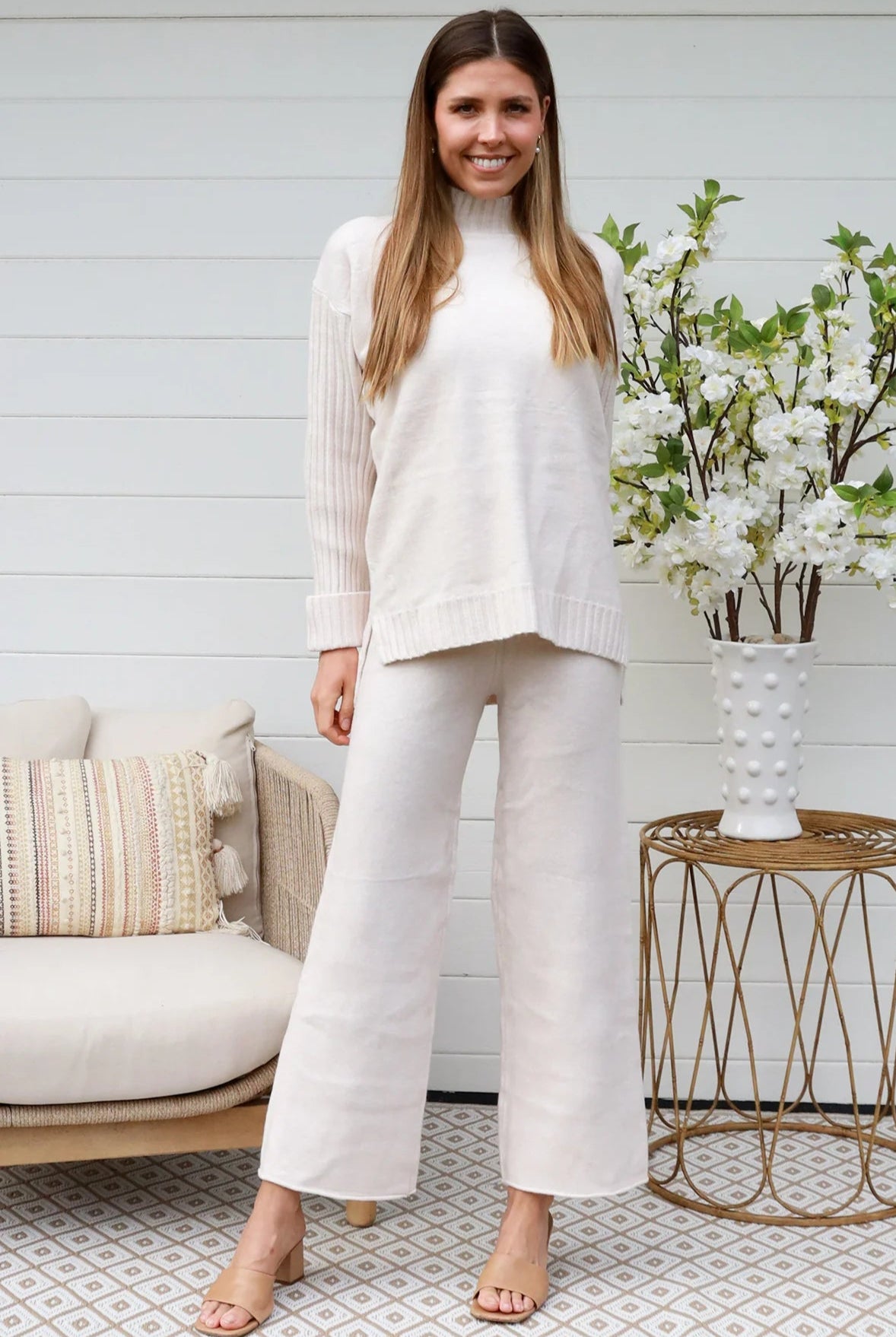 Model wearing cream knit lounge set with high-neck jumper and wide-leg pants - women's loungewear Australia.