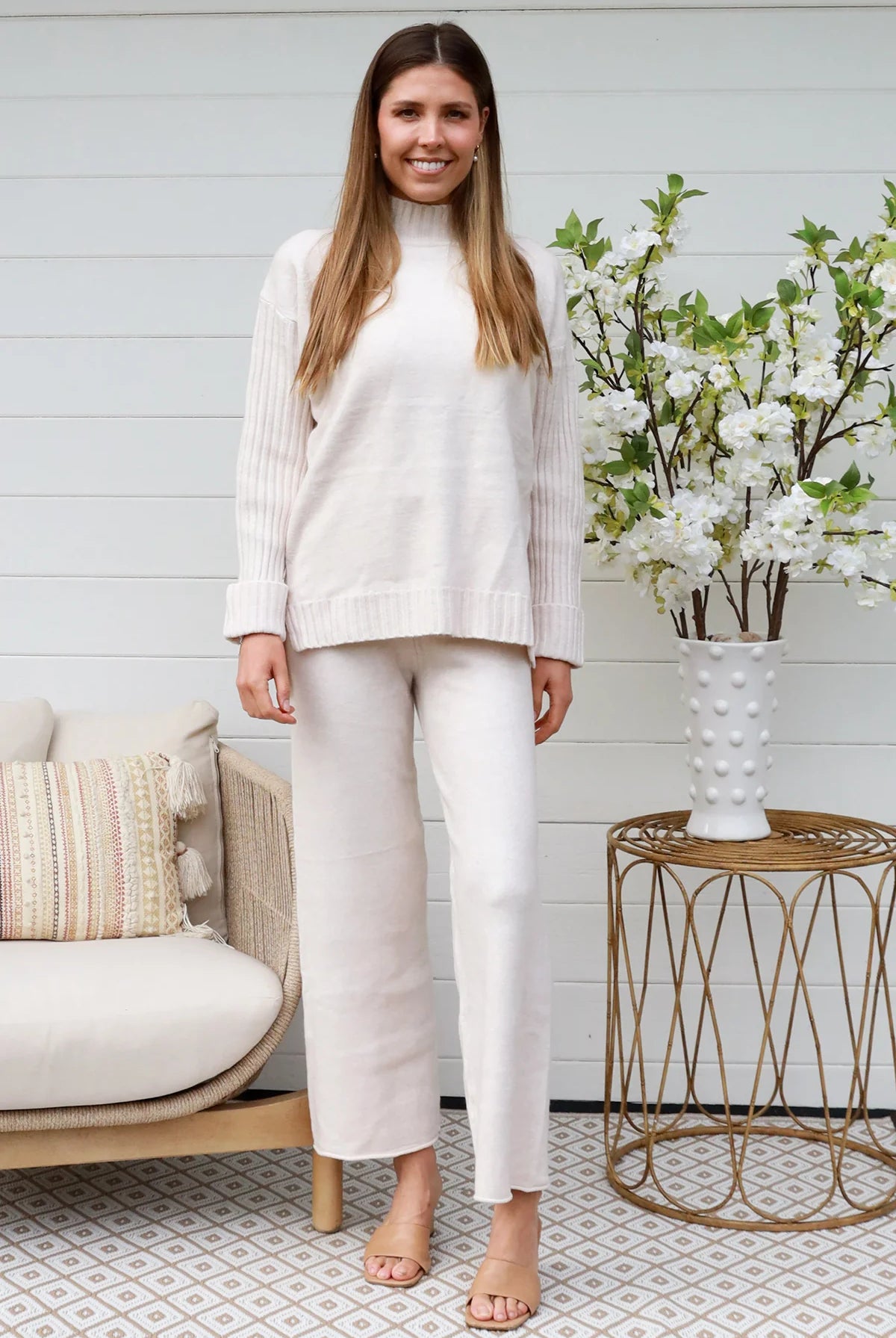 Model wearing cream knit lounge set with high-neck jumper and wide-leg pants - women's loungewear Australia.
