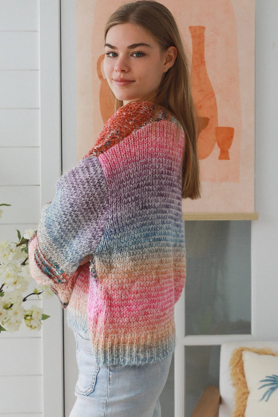 Woman wearing pastel stripe wool blend knit jumper with denim jeans and relaxed boho winter styling