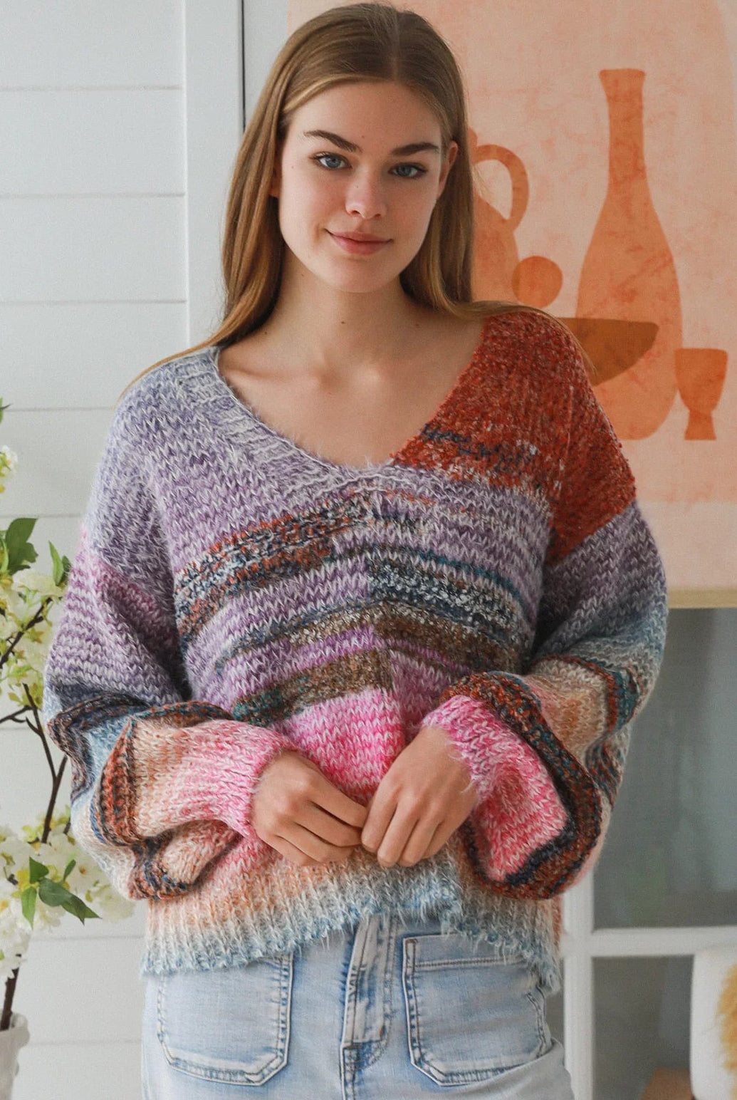 Woman wearing pastel stripe wool blend knit jumper with denim jeans and relaxed boho winter styling