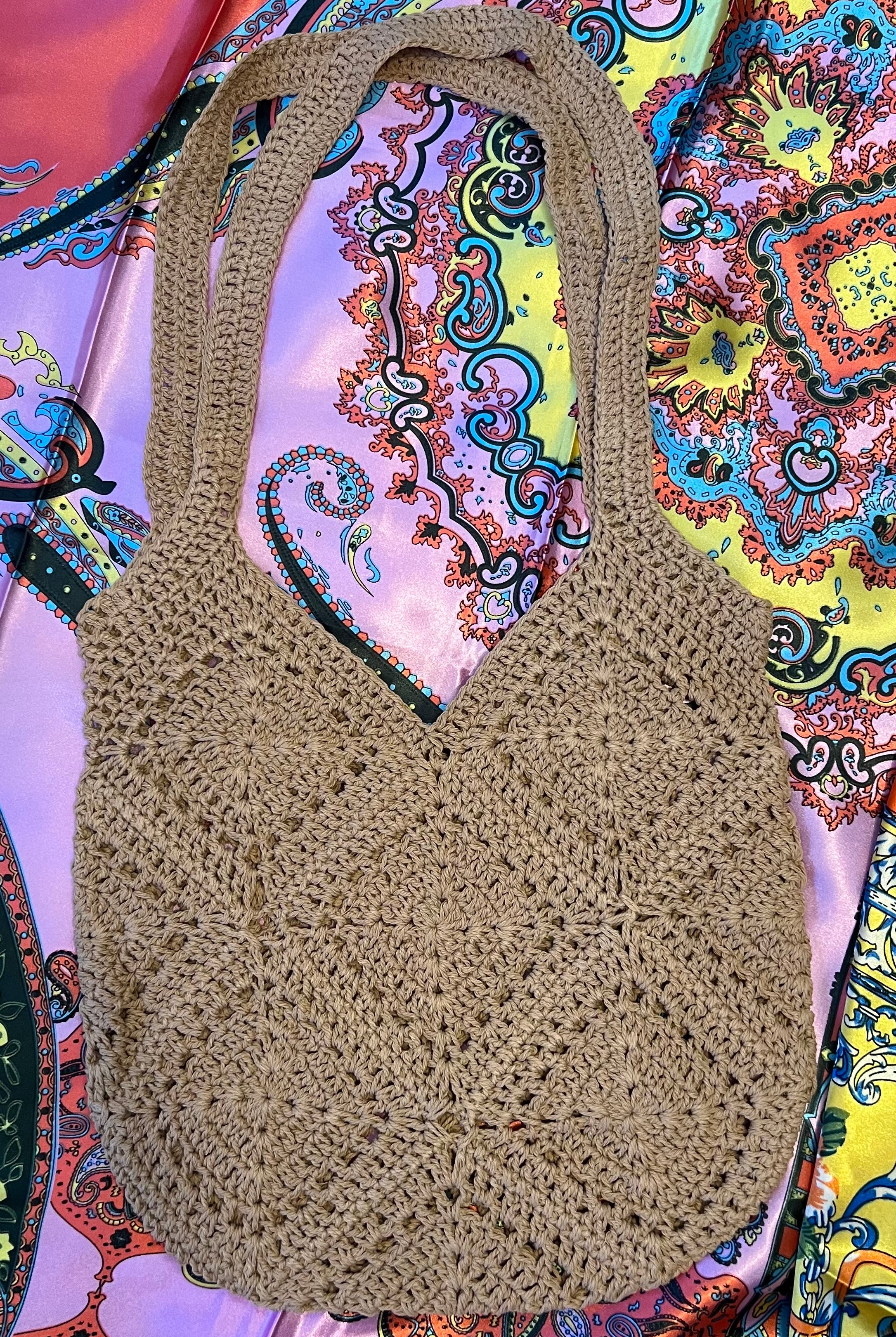 Tan crochet shoulder bag laid flat on a vibrant boho scarf background - artisan-style boho accessory Australia.