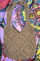 Tan crochet shoulder bag laid flat on a vibrant boho scarf background - artisan-style boho accessory Australia.