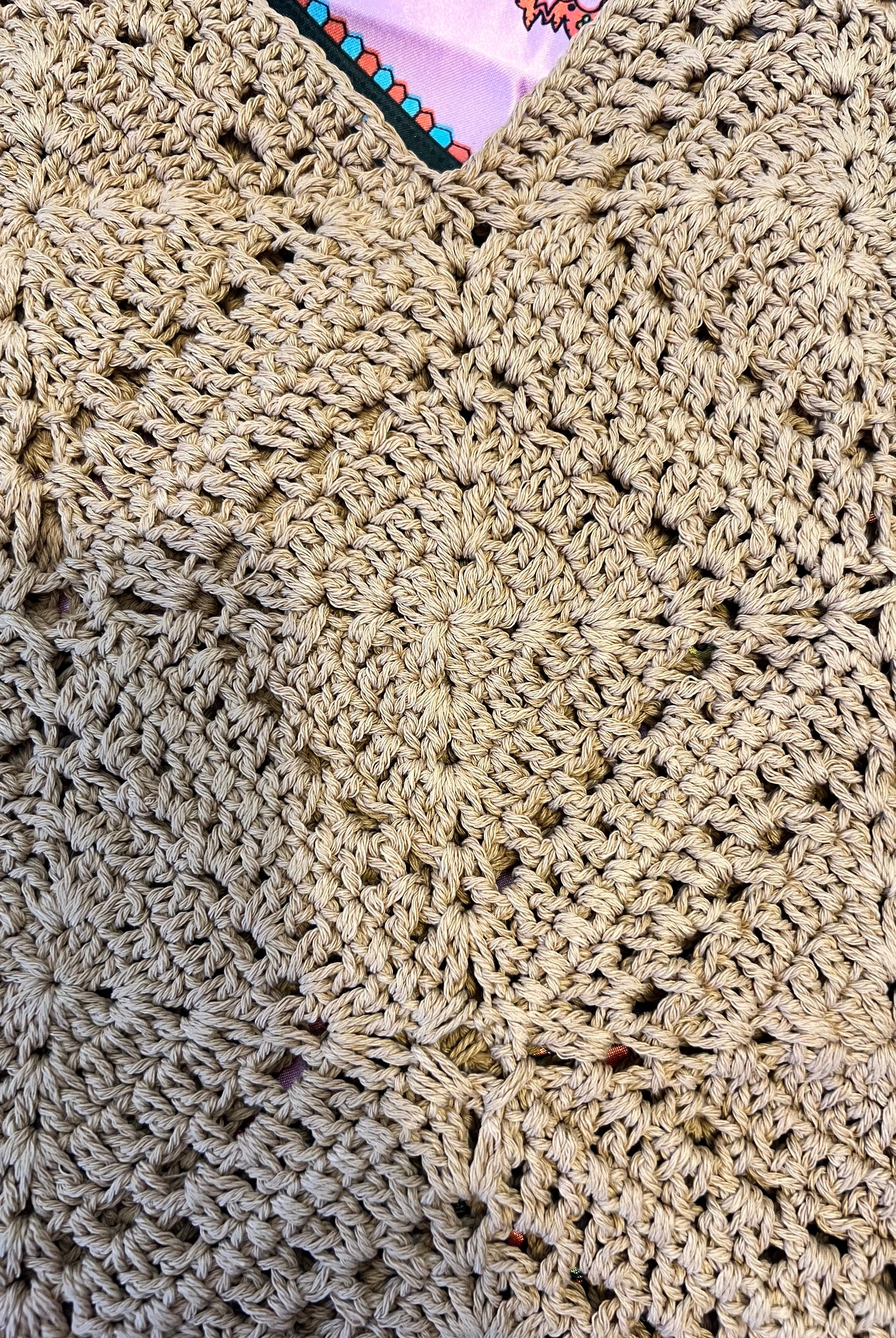 Tan crochet shoulder bag laid flat on a vibrant boho scarf background - artisan-style boho accessory Australia.