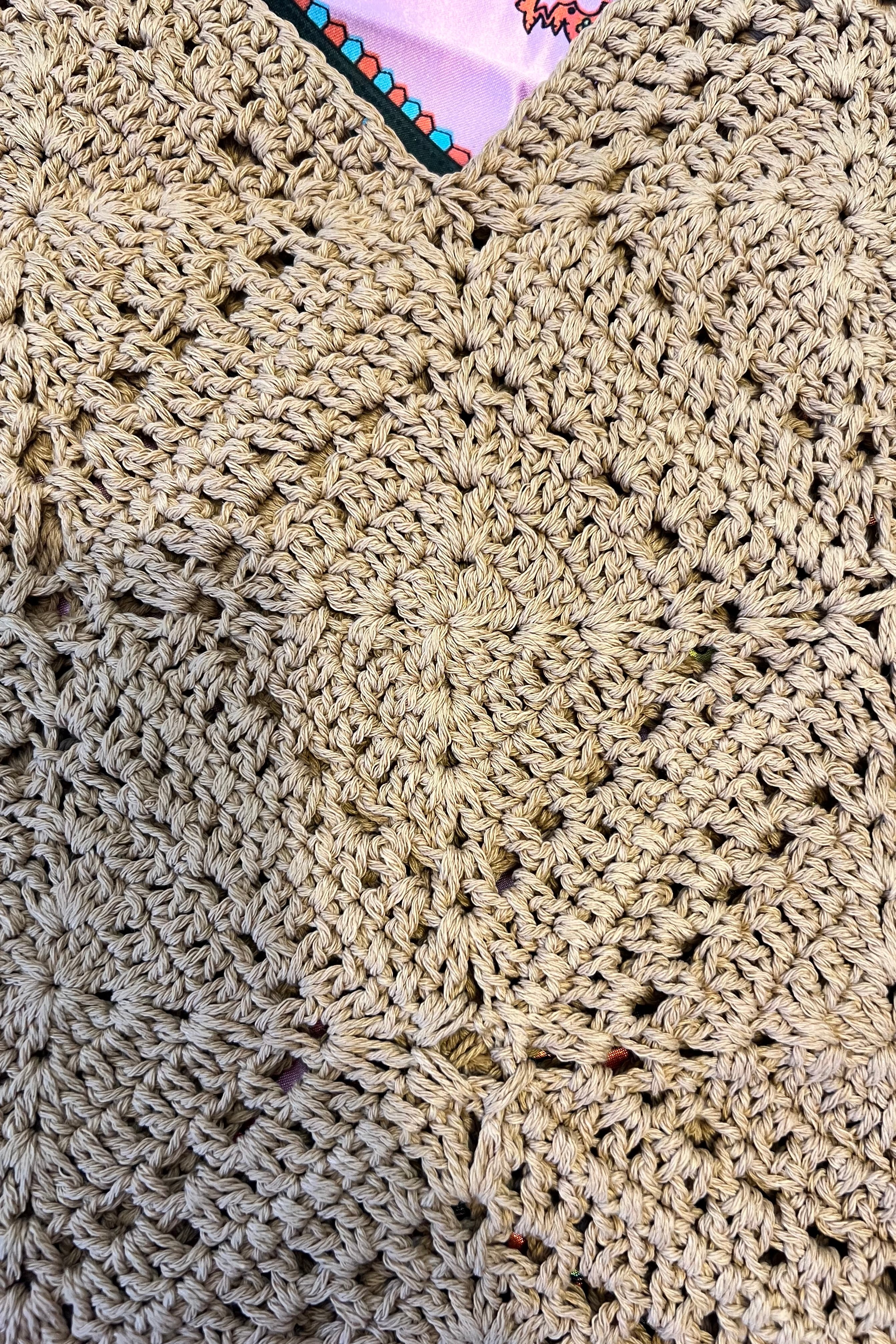 Tan crochet shoulder bag laid flat on a vibrant boho scarf background - artisan-style boho accessory Australia.