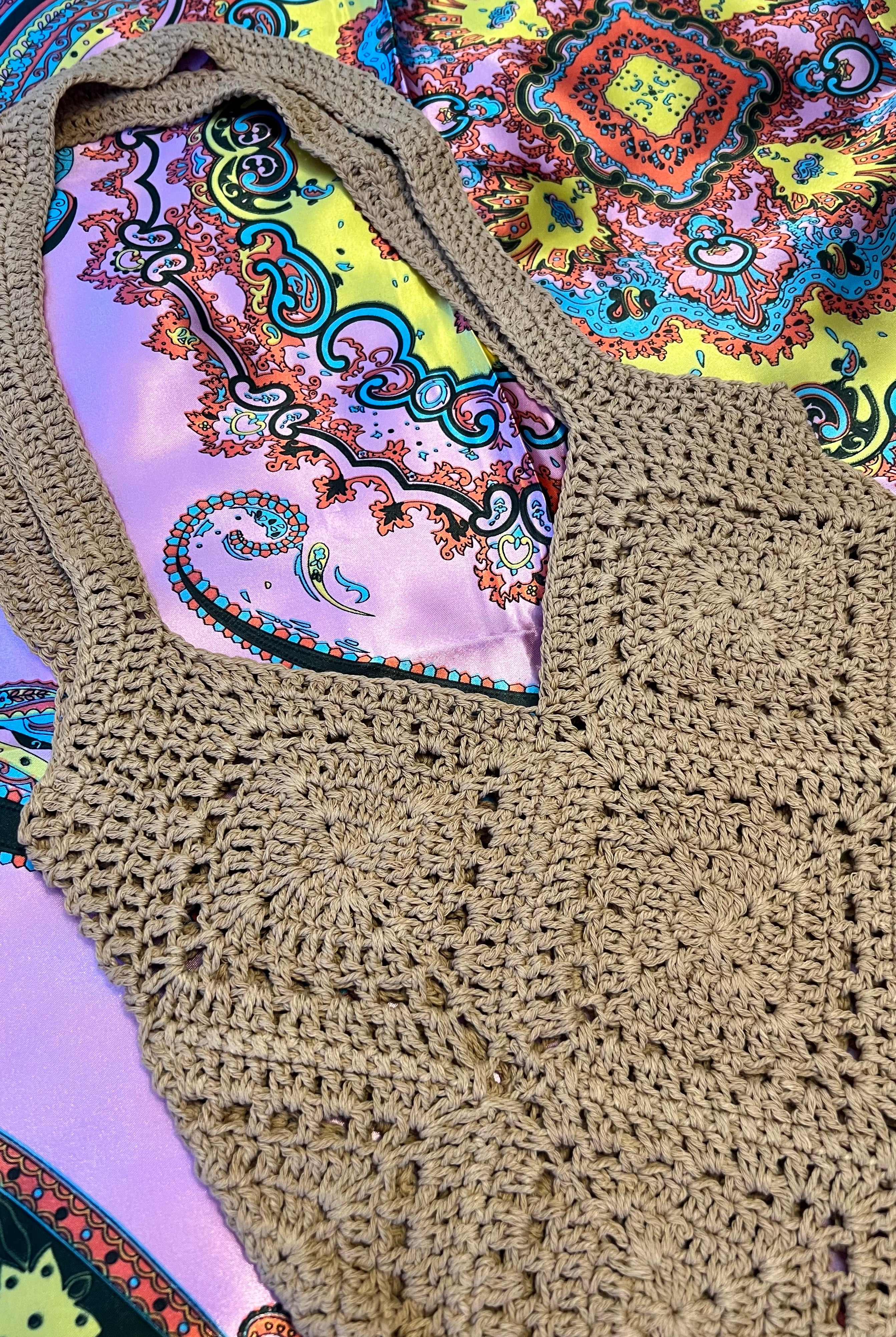 Tan crochet shoulder bag laid flat on a vibrant boho scarf background - artisan-style boho accessory Australia.