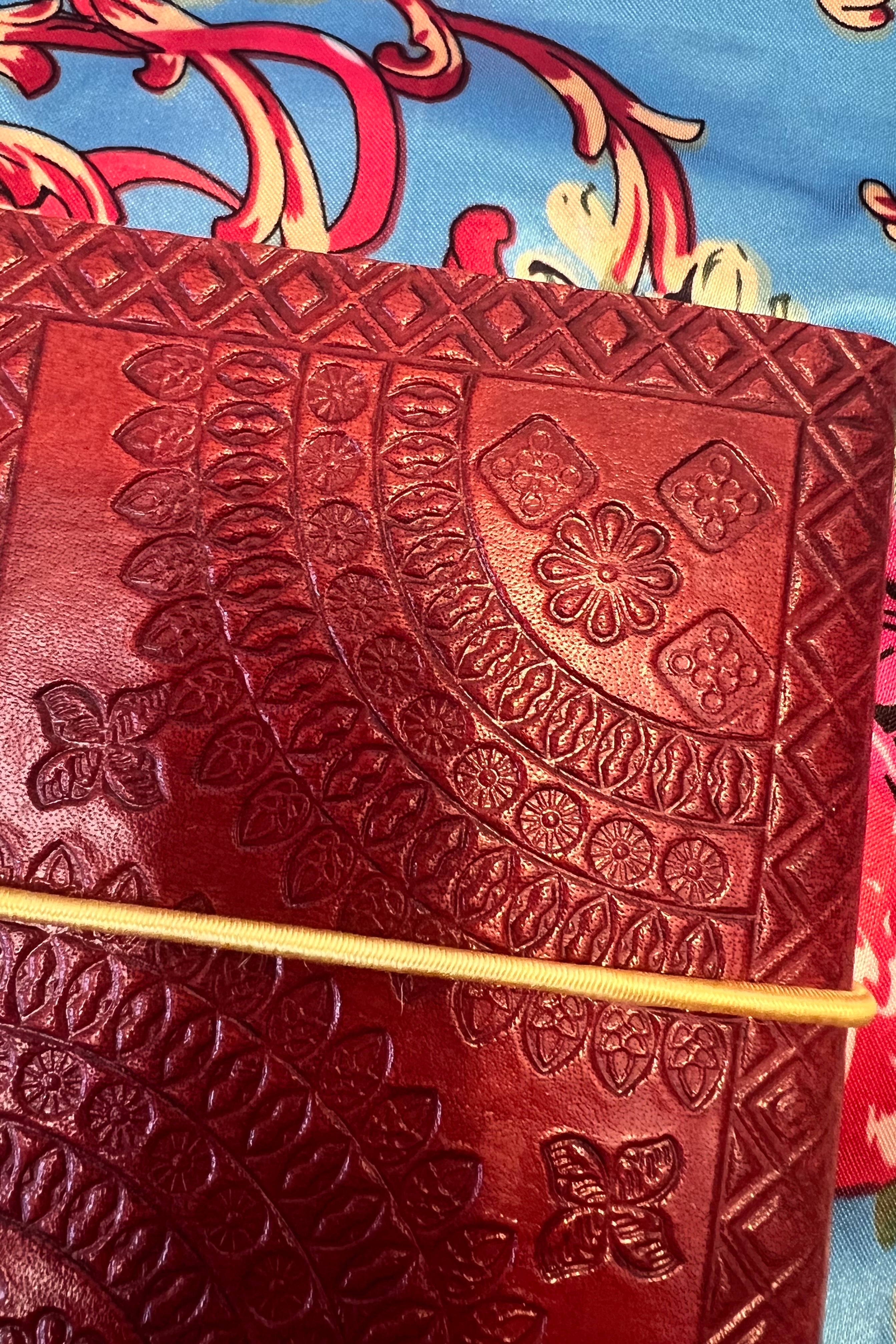 Golden-brown hand-tooled leather B5 journal with embossed curved pattern and blank recycled pages - boho artisan notebook