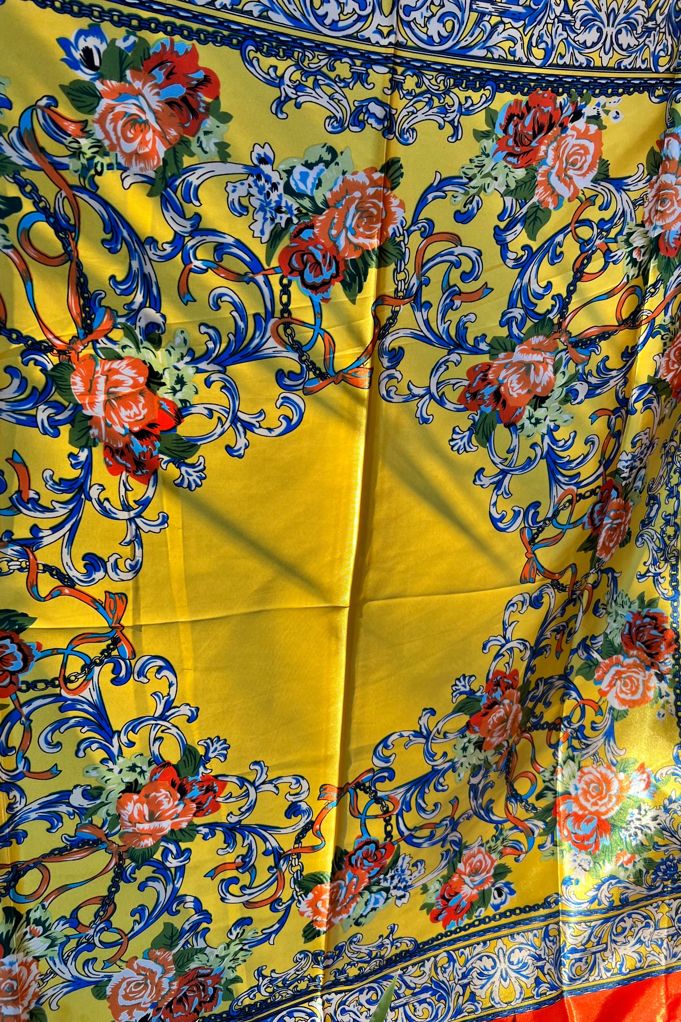 Yellow satin scarf with blue baroque scrolls and red floral print draped in sunlight - boho satin scarves Australia.