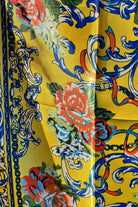 Yellow satin scarf with blue baroque scrolls and red floral print draped in sunlight - boho satin scarves Australia.