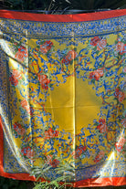 Yellow satin scarf with blue baroque scrolls and red floral print draped in sunlight - boho satin scarves Australia.