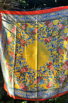 Yellow satin scarf with blue baroque scrolls and red floral print draped in sunlight - boho satin scarves Australia.