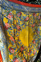 Yellow satin scarf with blue baroque scrolls and red floral print draped in sunlight - boho satin scarves Australia.