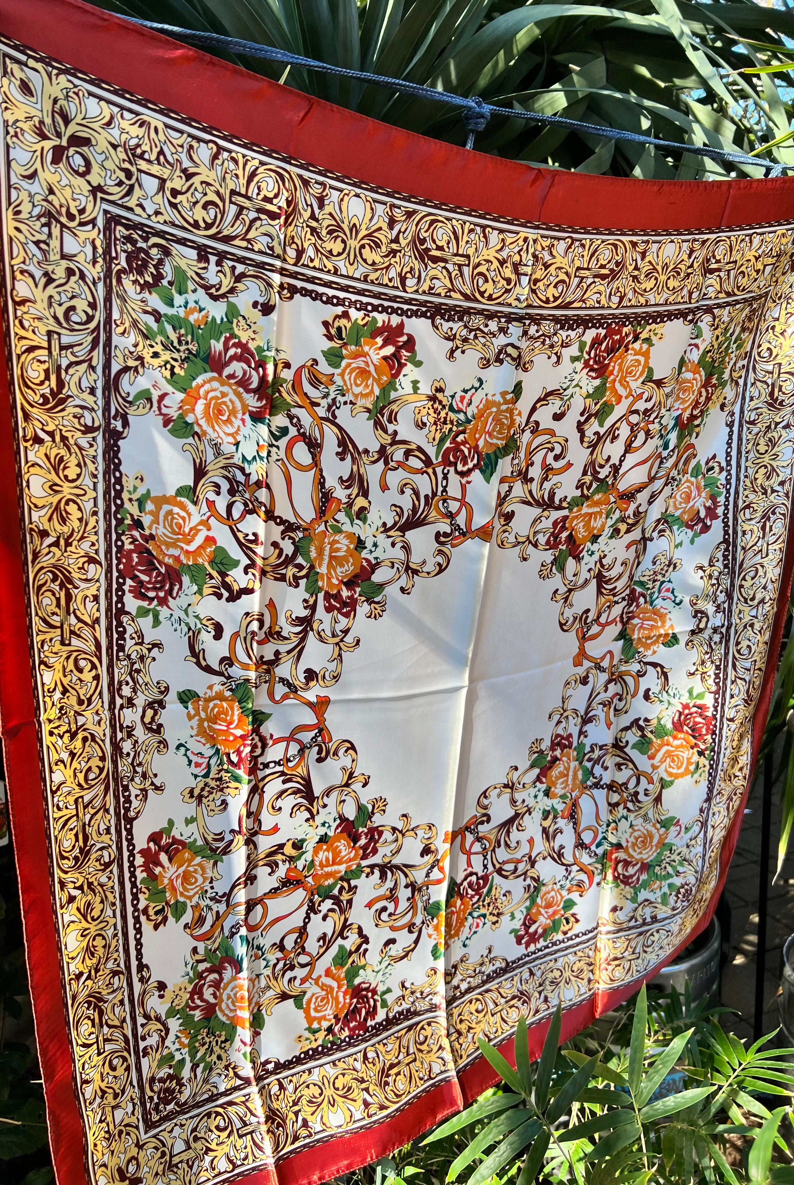 Brown satin square scarf with baroque floral print and red border in vintage-inspired warm tones.