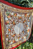 Brown satin square scarf with baroque floral print and red border in vintage-inspired warm tones.