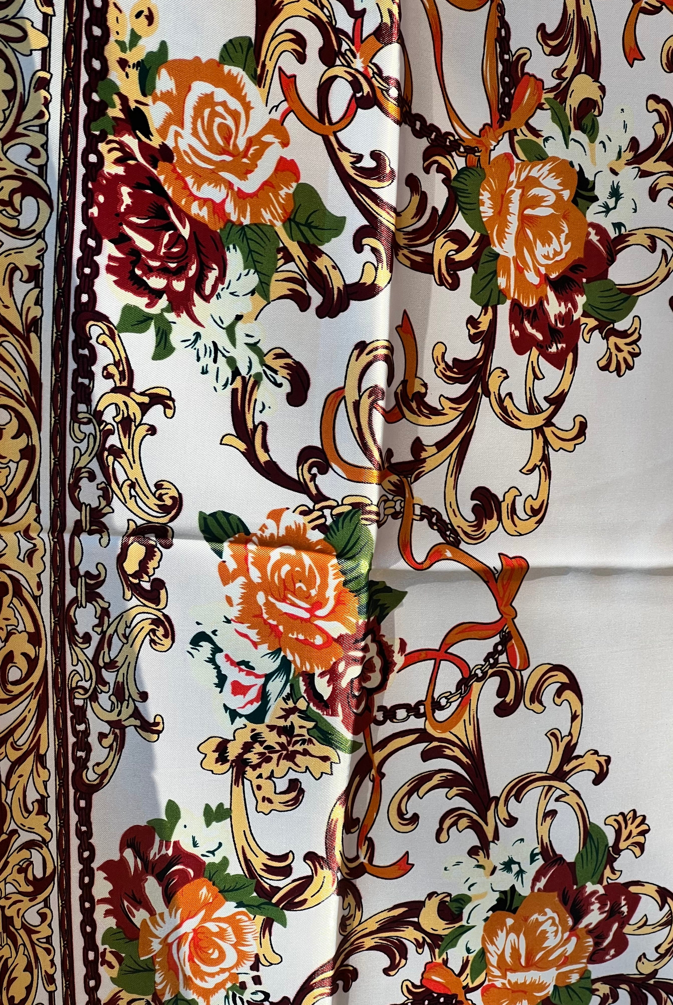 Brown satin square scarf with baroque floral print and red border in vintage-inspired warm tones.