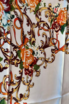 Brown satin square scarf with baroque floral print and red border in vintage-inspired warm tones.