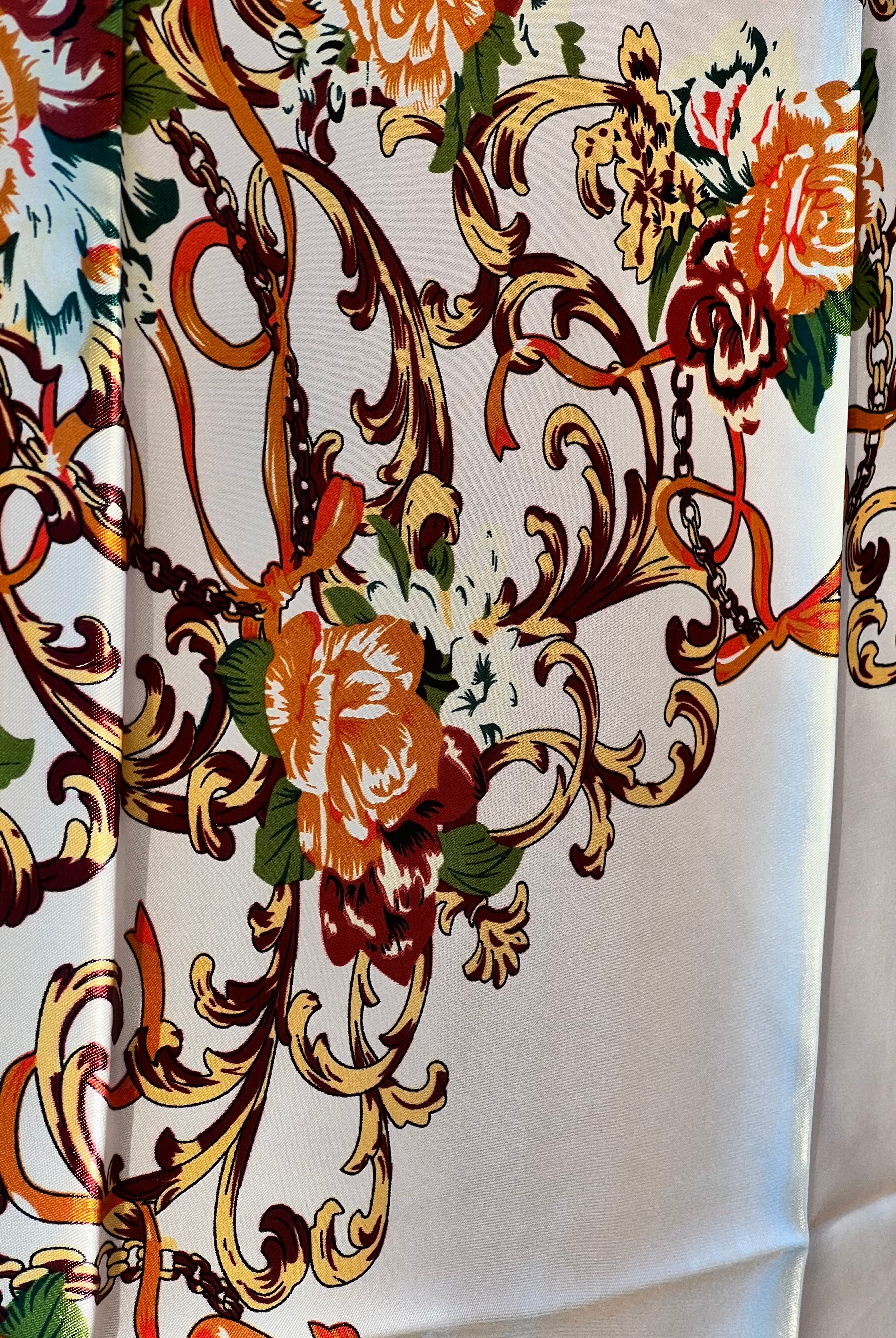 Brown satin square scarf with baroque floral print and red border in vintage-inspired warm tones.