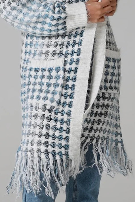 Woman wearing Juliet white and blue houndstooth longline fringe knit cardigan with drop shoulder sleeves, ribbed cuffs and front pockets by Charlotte The Label.